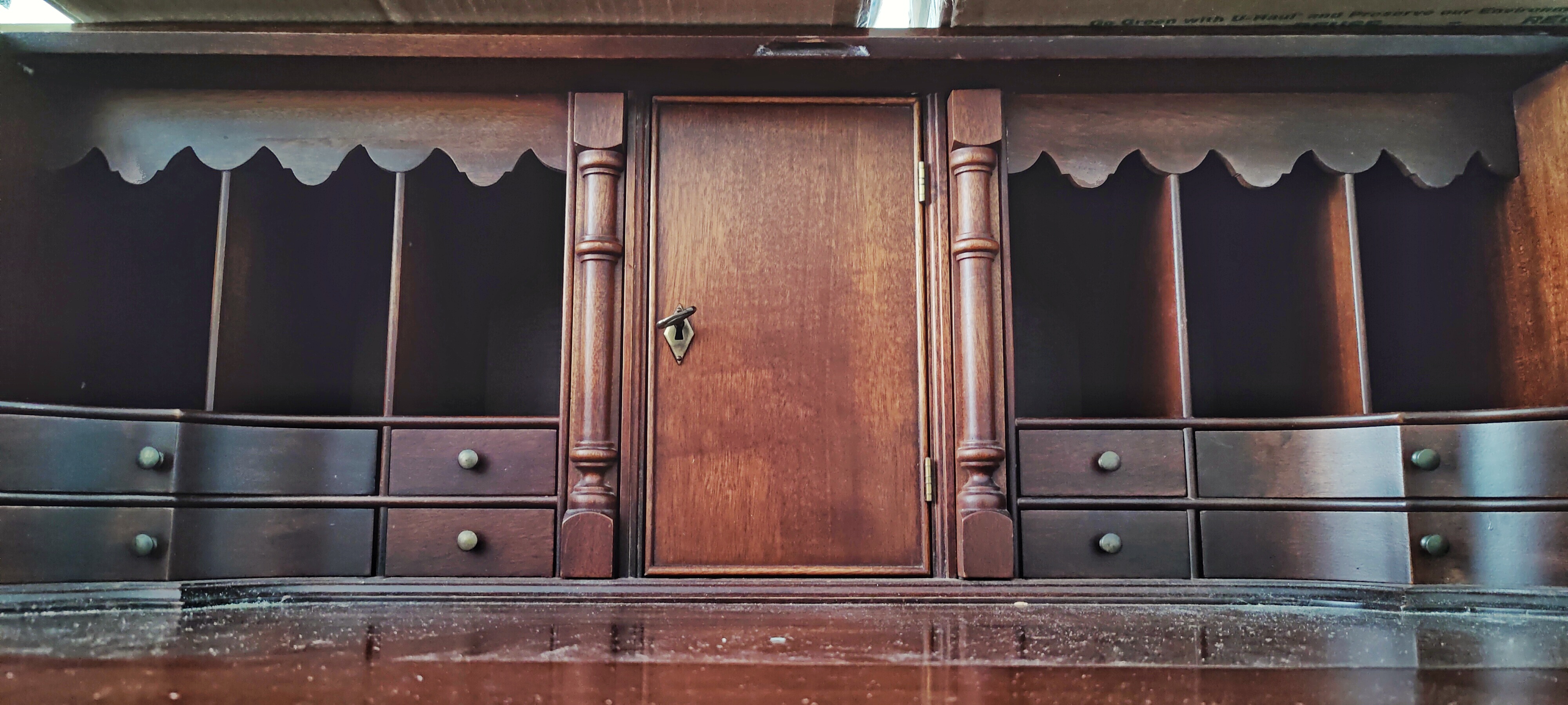 zoomed-in view of an opened secretary desk, with a small locked door in the middle, surrounded by cubbies and drawers on either side